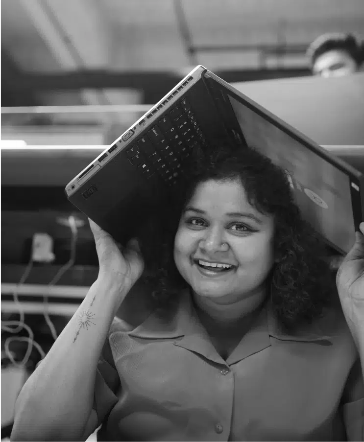 Portrait-of-smiling-UX-Team-member-isolated-holding-laptop-above-her-head.